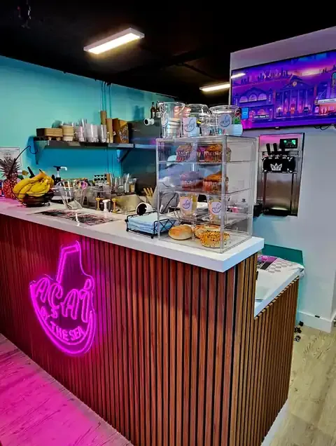 Inside Açaí By The Sea — the counter and neon sign